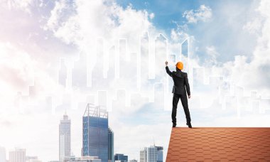 Mühendis, evinin çatısına geri döndü ve şehri çiziyor. Karışık ortam