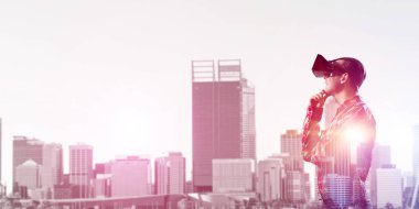 Sanal gerçeklik kulaklığı olan genç bir adam ya da şehrin arka planında 3 boyutlu gözlüklü.