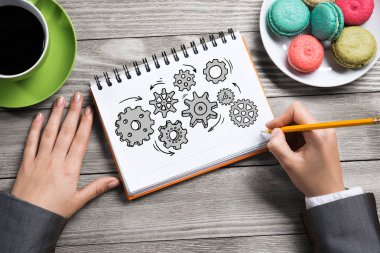 İş kadını elinde görüntülemek için Not Defteri'nde çizim mekanizma-vites