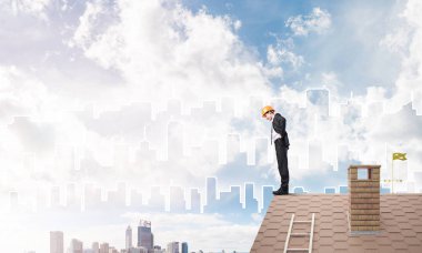 Makinist çatıda dikilip aşağıya bakıyor. Karışık ortam