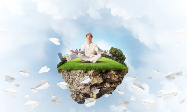 目を保つ白い服の男が閉じられ 背景に曇り空の景色と紙飛行機を飛行中の空気の島に瞑想しながら集中して見ています レンダリング — ストック写真