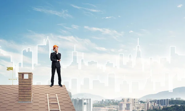 Ingenjör man står på taket och tittar bort. Blandade medier — Stockfoto