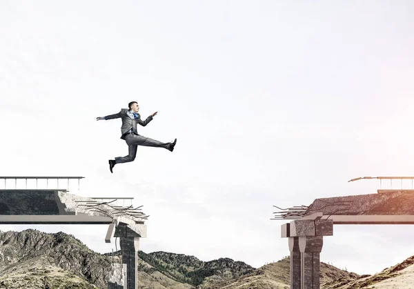 Empresário Pulando Sobre Enorme Lacuna Ponte Concreto Como Símbolo Superar — Fotografia de Stock