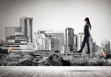 İş konsepti risk desteği ve ipte dengede duran adama yardım