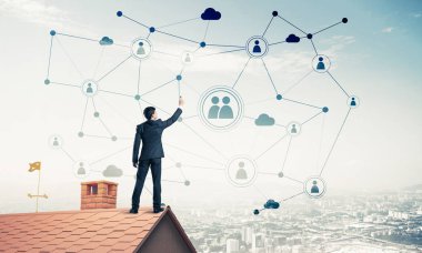 Delikanlı çatıda dikiliyor ve bağlantı hatları çiziyor. Karışık ortam