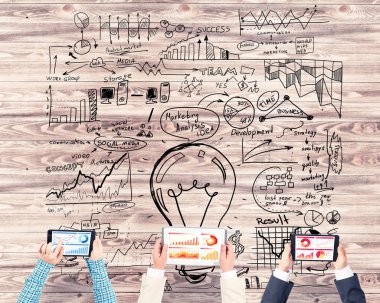 Ellerinde cihazlar bulunan üç kişilik bir grup iletişim ve ağ oluşturma sembolü olarak birlikte çalışıyor.