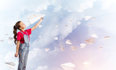 Kağıt Uçak ile oynarken gökyüzü arka plan karşı küçük şirin kız