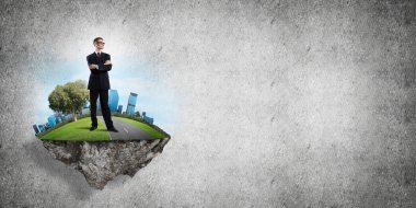 Yeşil yüzen adada beton zemine karşı duran kendine güvenen zarif iş adamı.