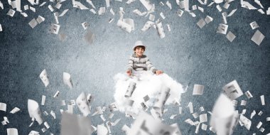 Genç küçük çocuk gözleri koruma kapalı ve seyir üzerinde uçan bulut ile gri karanlık duvar kağıtları arka plan üzerinde uçan arasında meditasyon sırasında konsantre.