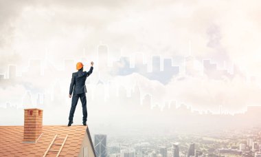 Mühendis, evinin çatısına geri döndü ve şehri çiziyor. Karışık ortam