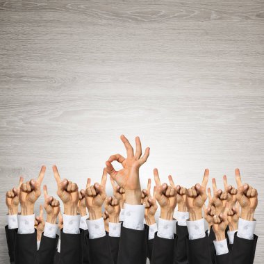 Bir grup iş adamı ahşap arka planda jestler gösteriyor.