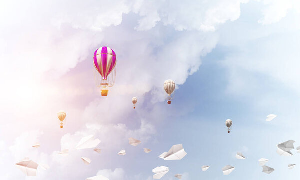 Красочные аэростаты, летающие среди бумажных самолетов и над голубым облачным небом. 3D рендеринг
.