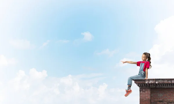 Concept of careless happy childhood with girl showing touch gesture — Stock Photo, Image