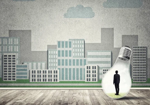 Businessman inside light bulb against city drawn concept