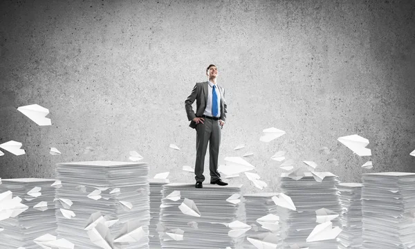Confident Businessman Suit Standing Pile Documents Flying Paper Planes Grey — Stock Photo, Image