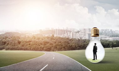 Genç işadamı asfalt yolda ampulün içinde mahsur kaldı.