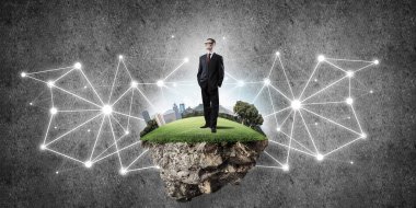 Uçan yeşil adada beton zeminde zarif bir işadamı.