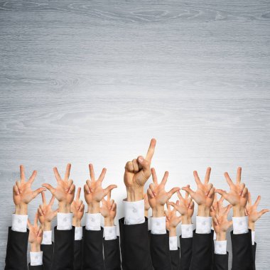 Bir grup iş adamı ahşap arka planda jestler gösteriyor.