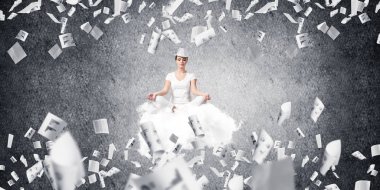 Kadın beyaz giyim gözler tutmak kapalı ve seyir üzerinde uçan bulut ile karanlık duvar kağıtları arka plan üzerinde uçan arasında meditasyon sırasında konsantre.