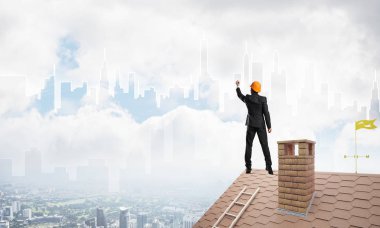 Mühendis, evinin çatısına geri döndü ve şehri çiziyor. Karışık ortam