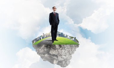 Mavi gök yeşil yüzen ada üzerinde duran zarif emin iş adamı