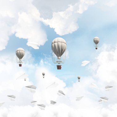 Renkli aerostats kağıt uçaklar arasında ve mavi bulutlu gökyüzü üzerinde uçan. 3D render.