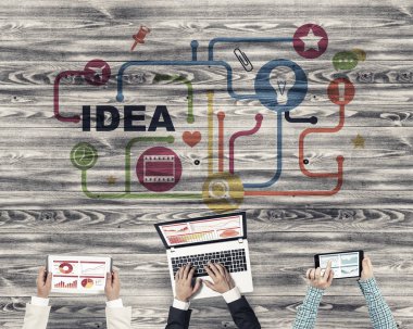 Ellerinde cihazlar bulunan üç kişilik bir grup iletişim ve ağ oluşturma sembolü olarak birlikte çalışıyor.