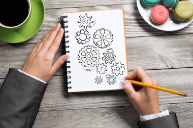 İş kadını elinde görüntülemek için Not Defteri'nde çizim mekanizma-vites