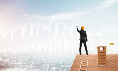 Mühendis, evinin çatısına geri döndü ve şehri çiziyor. Karışık ortam