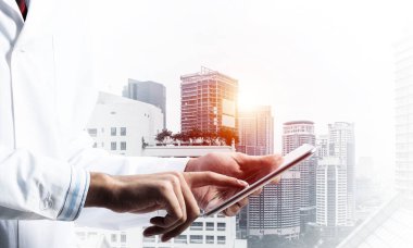 Çift pozlama bir arka plan üzerinde beyaz steril önlük wirh modern cityscape görünümünde emin doktor. Modern tıp sektöründe kavramı