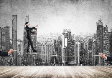 İş konsepti risk desteği ve ipte dengede duran adama yardım