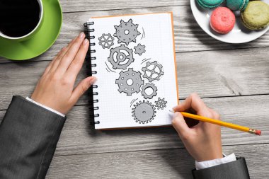 İş kadını elinde görüntülemek için Not Defteri'nde çizim mekanizma-vites