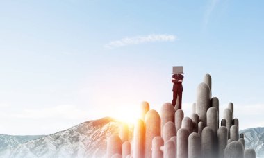 Arka plan üzerinde duran güzel gökyüzü ile taş sütun üst dizüstü bilgisayar kafasına silah tutmak yerine ile takım elbiseli işadamı geçti.