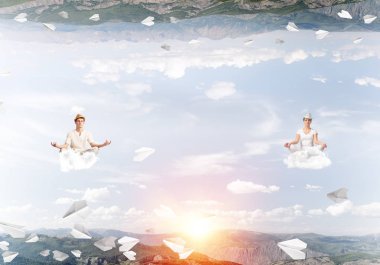 Genç çift gözleri koruma kapalı ve seyir bulutlar arasında kağıt uçaklar uçuyor ve doğa dünyalar arasında üzerinde meditasyon sırasında konsantre.