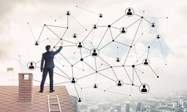 Delikanlı çatıda dikiliyor ve bağlantı hatları çiziyor. Karışık ortam