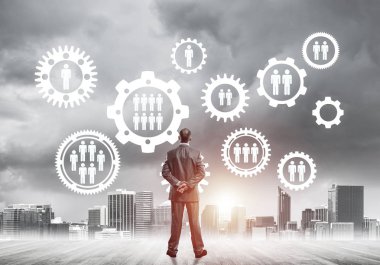 Modern şehir manzarası ve vites bağlantısı fikrine bakan işadamlarının arka planı