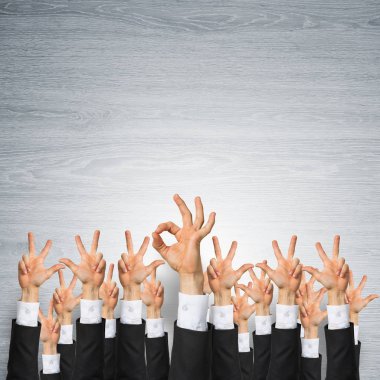 Bir grup iş adamı ahşap arka planda jestler gösteriyor.