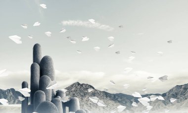 Açık havada, arka planda güzel manzarası olan uçan kağıt uçaklar arasında yer alan yüksek ve büyük taş sütunların resmi. Duvar kağıdı, telif alanı olan arkaplan.