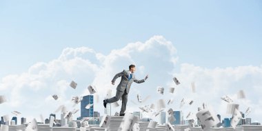 Takım elbise ile telefonu elinde kağıt belgeleri Clear sky ile arka plan üzerinde uçan arasında çalışan iş adamı. Karışık teknik.