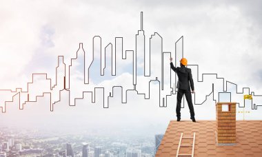 Mühendis, evinin çatısına geri döndü ve şehri çiziyor. Karışık ortam