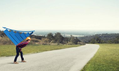 Genç inşaatçı sırtında büyüyen grafikler taşıyor.