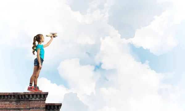 Concept d'enfance heureuse négligente avec fille rêvant de devenir pilote — Photo