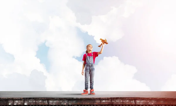 Concept d'enfance heureuse négligente avec fille rêvant de devenir pilote — Photo