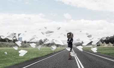 İş kadını kıyafetli kafa silah tutmak yerine eski Tv ile ayakta kağıt uçaklar güzel manzara ile arka plan üzerinde uçan arasında yol üzerinde çarpı işareti.