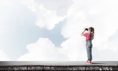 Dürbünle bakan, okul çağındaki sevimli kız çatıyı inşa ediyor.