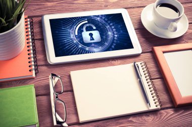 Ofis eşyalarıyla iş yeri ve ekranda asma kilit simgeleri olan tablet