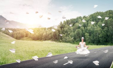 Genç kadın gözleri koruma kapalı ve seyir ile güzel ve nefes kesici manzara arka plan üzerinde bulut yukarıda yolun üzerinde meditasyon sırasında konsantre.