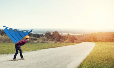 Genç inşaatçı sırtında büyüyen grafikler taşıyor.