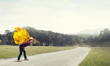 Sırtında kağıt top taşıyan inşaatçı.