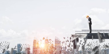 Genç takım elbiseli mühendis ve güneş ışığı ve arka plan üzerinde cityscape ile kırık köprü üzerinde harfler uçan arasında duran bakıyordu kask. 3D render.